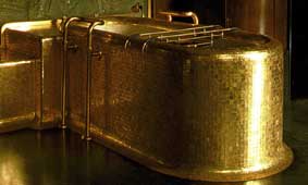 Bathtub covered in gold mosaic tiles
