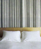 The wall clad frames rise 7 feet above the headboard of the bed