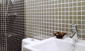 Stainless steel mosaic bathroom tiles add a luxurious and contemporary touch to this small bathroom