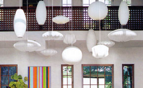 Decorative hanging lamps of various geometric shapes keep up the visual drama and accentuate the high ceiling